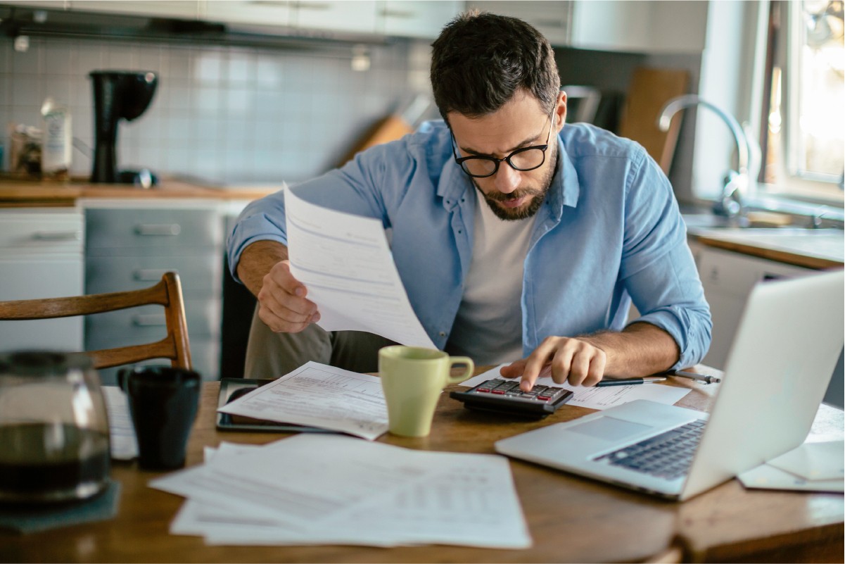 Man with glasses and calculator - Educators Financial Group