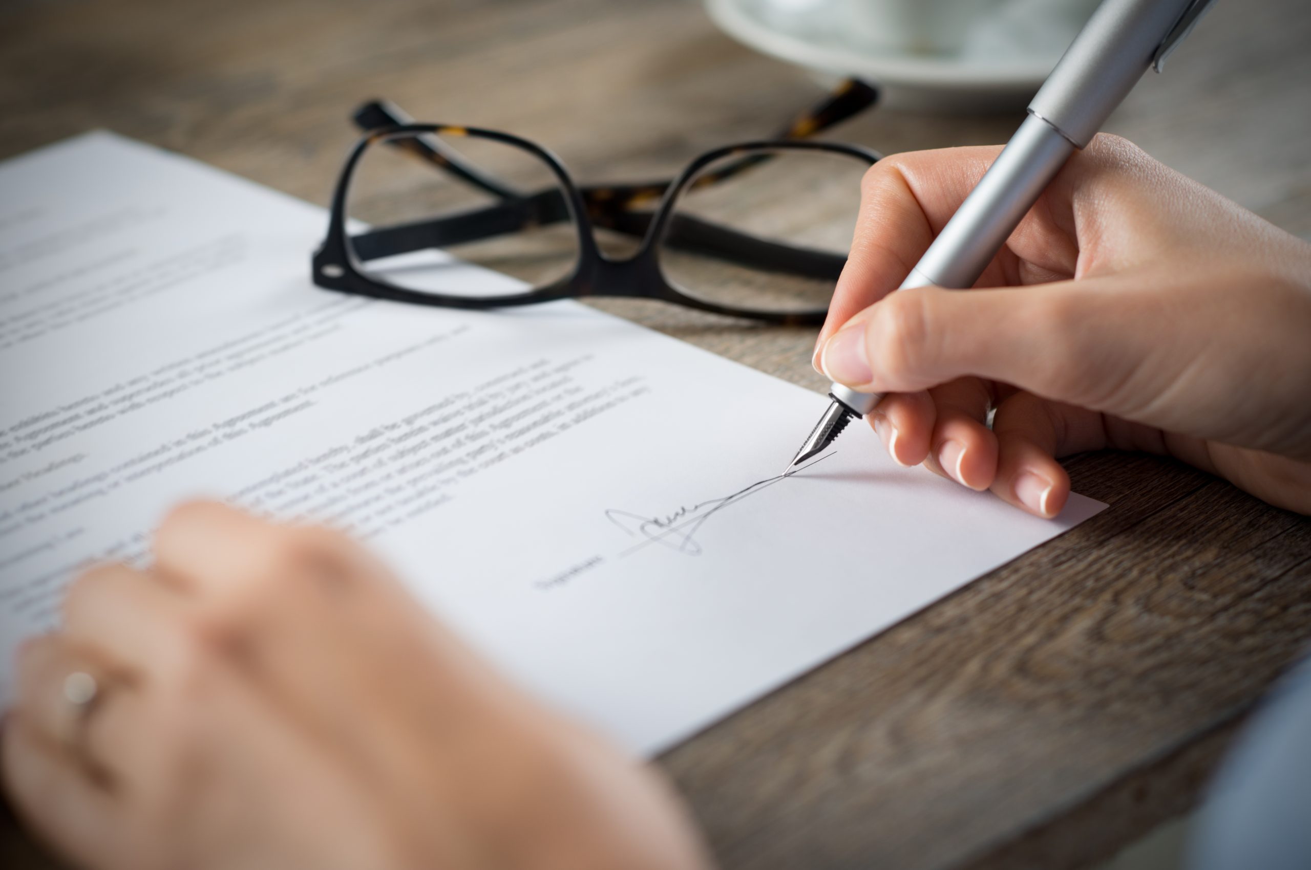 Close up of woman's hand signing a form