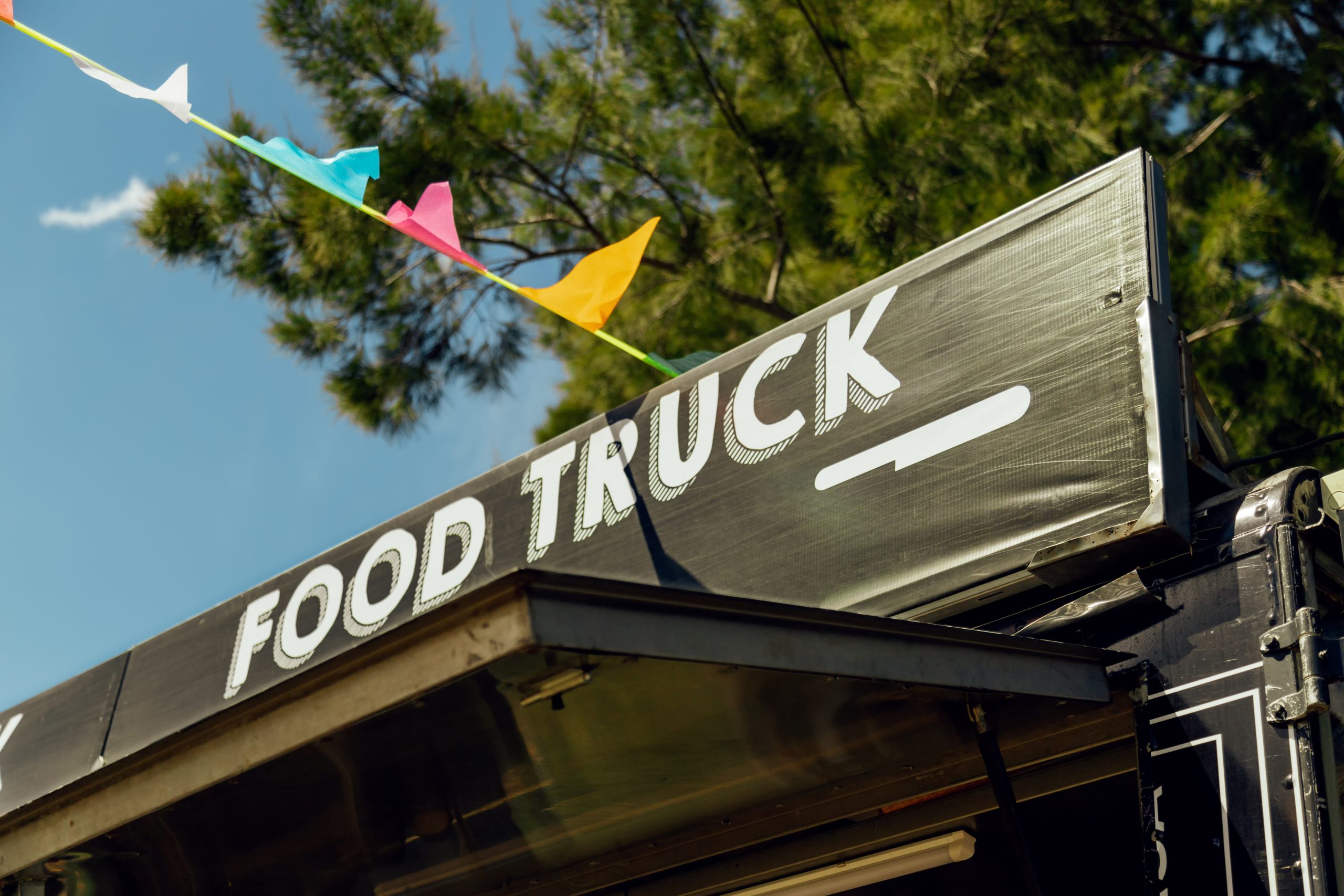 Signboard of a food truck with colorful pennants