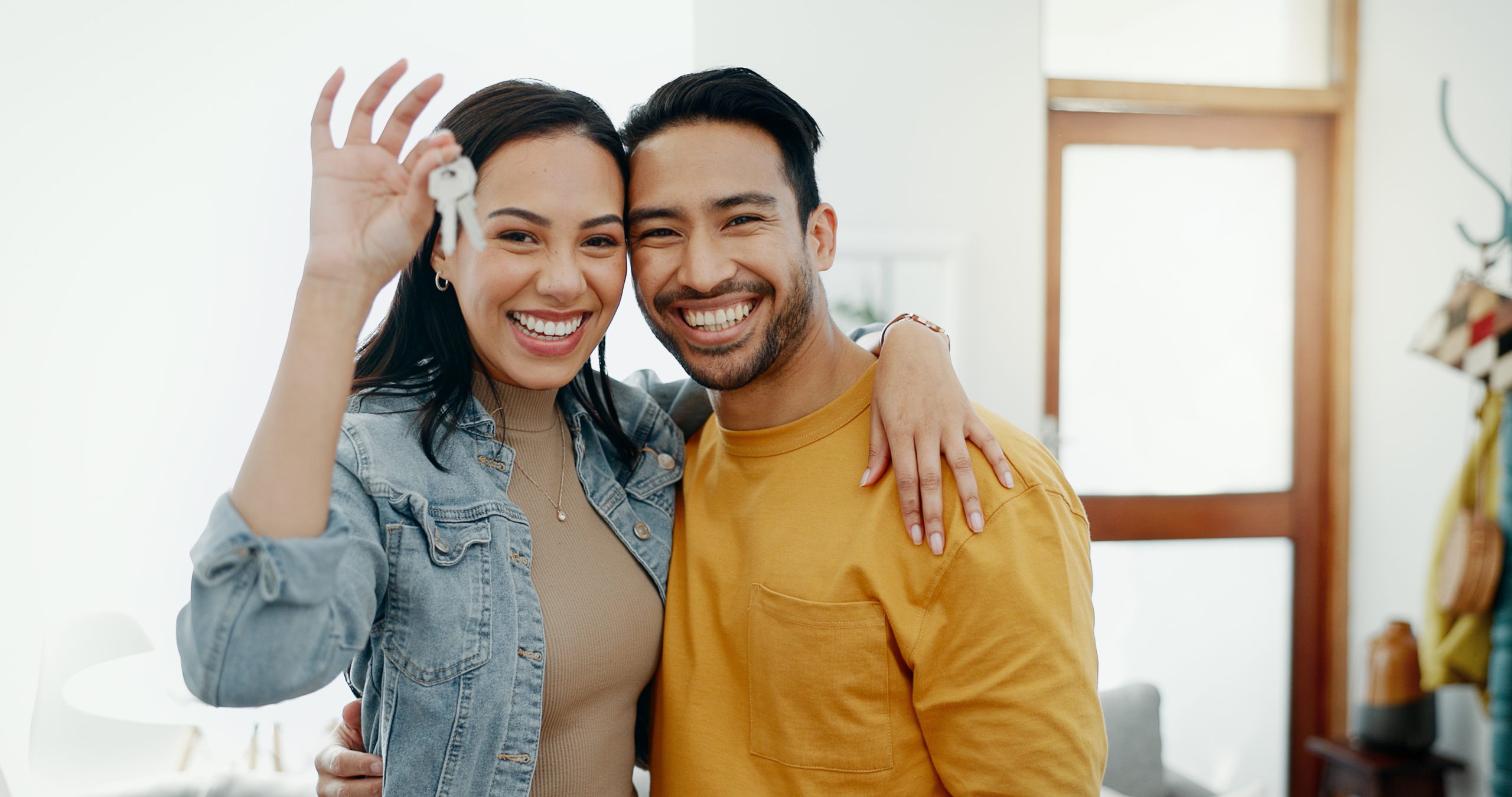 Young couple holding keys to their new home